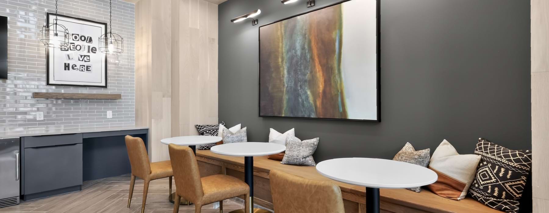 Modern resident lounge at Aspire at Greenville featuring café-style seating, built-in bench seating, and contemporary décor.